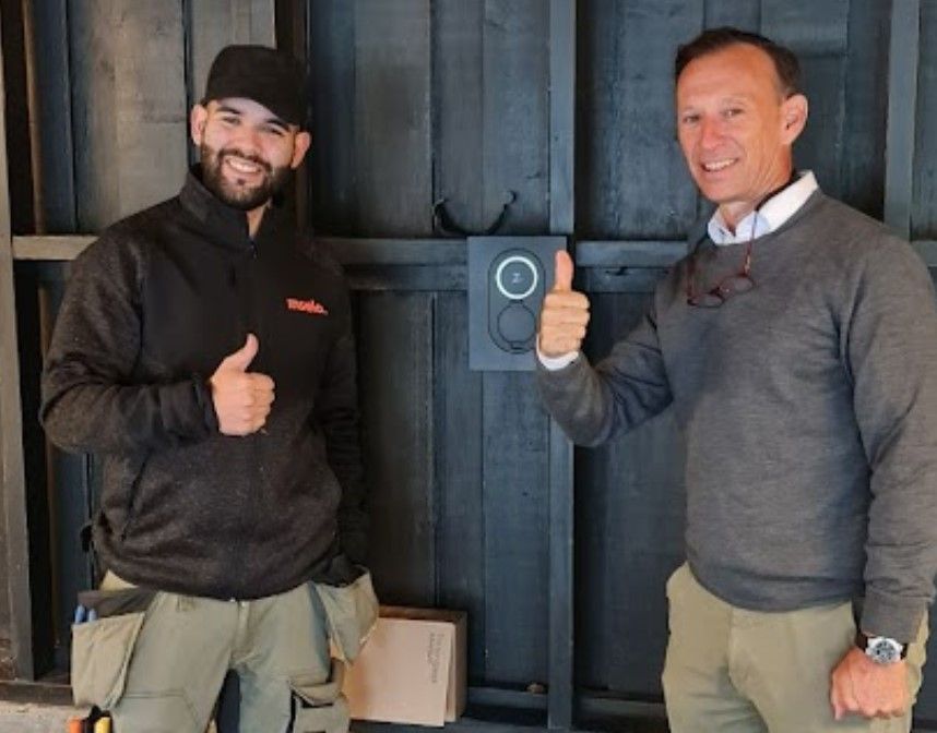 Fornøyd Tibber Kunde med sin nye lader ferdig installert sammen med kundereisehelten og elektrikeren Leik Sune Marchant