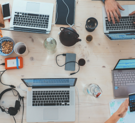 Laptops på et arbeidsbord med tekniske duppeditter 